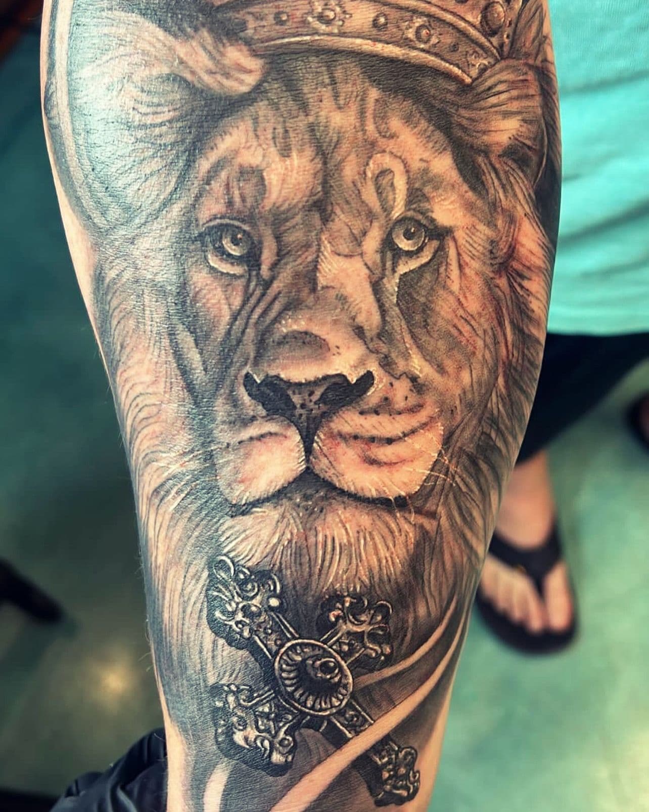 Black and grey realistic lion tattoo on forearm