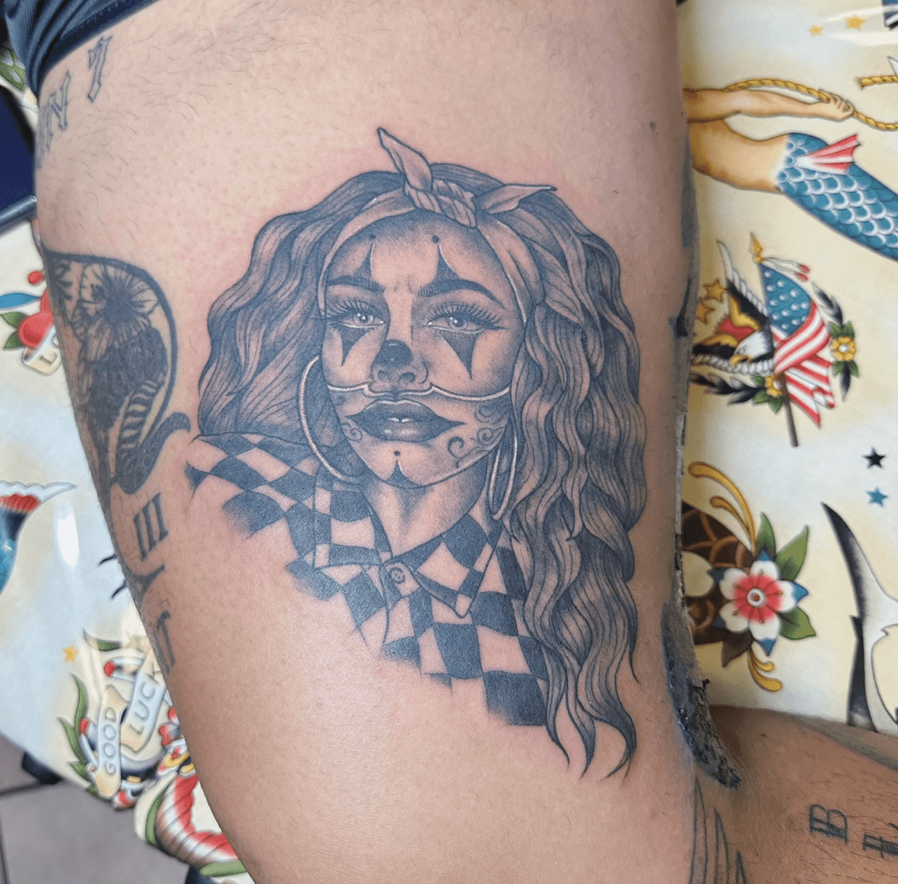 Black and grey portrait tattoo on thigh