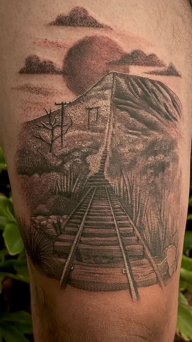 Black and grey realistic landscape tattoo on thigh