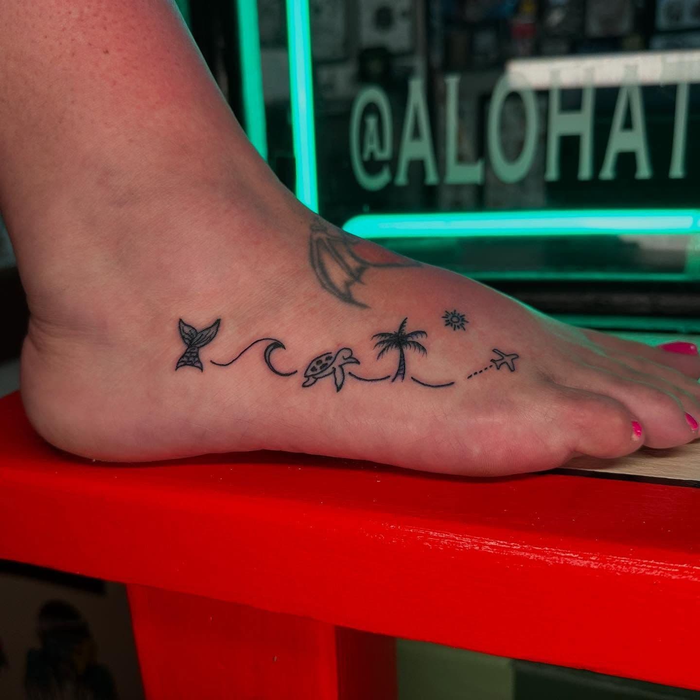 Minimalist black line beach elements tattoo on foot